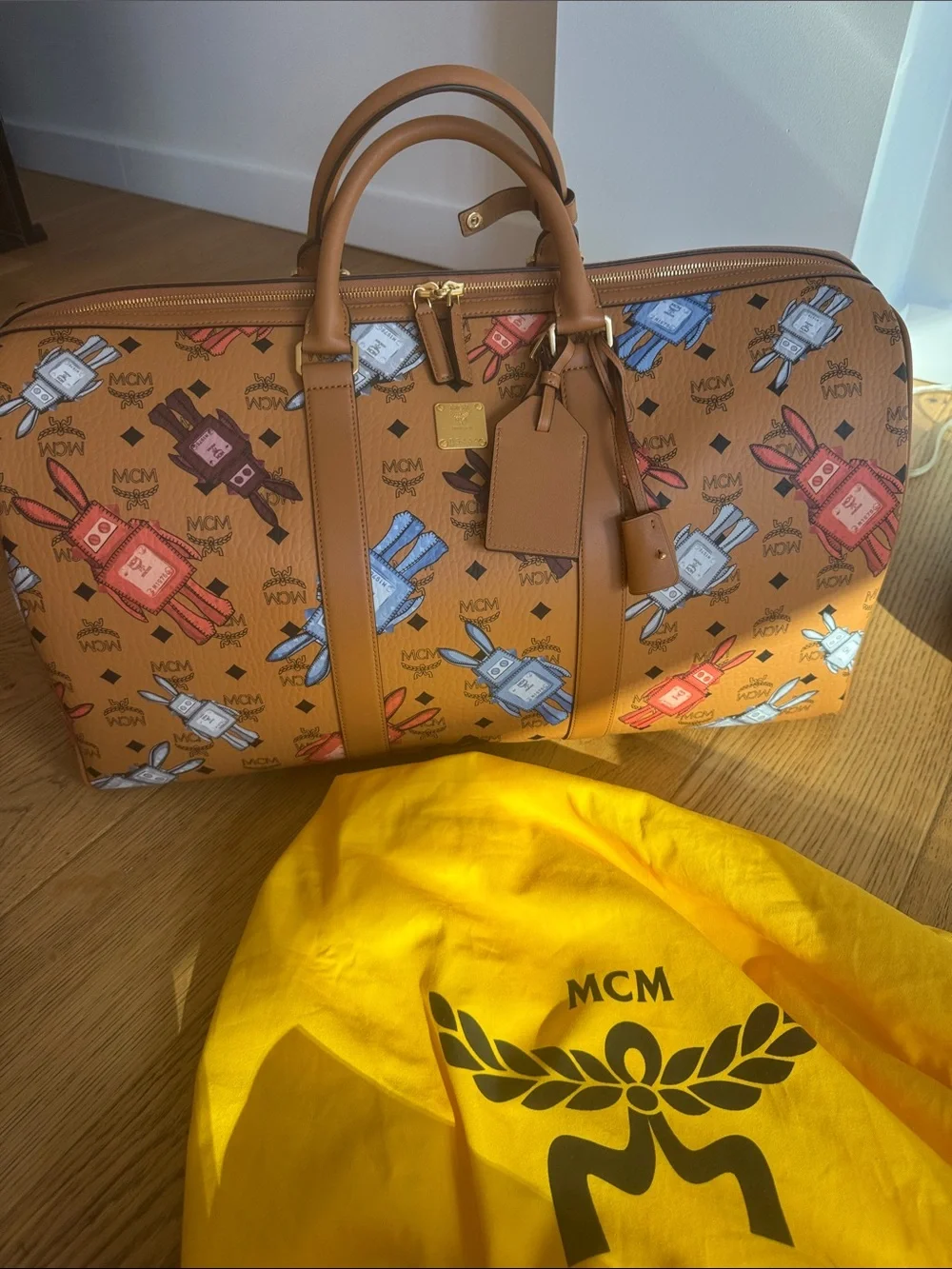 Brand New MCM Cognac Visetos Weekender with Multicolor Perfume Bottle Print.